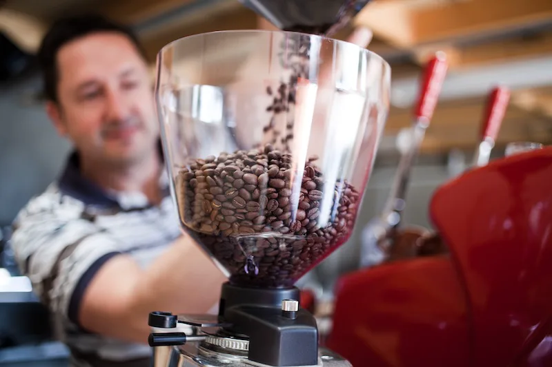 Chris at Talk Coffee loading beans into the grinder